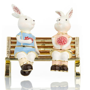 2 bunnies in love sitting on a bench, valentine flowers and chocolates